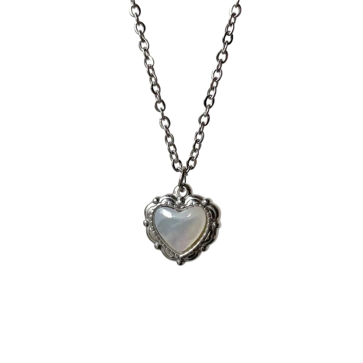 Heart-shaped pendant necklace with fresh water pearl inset on a light gray background