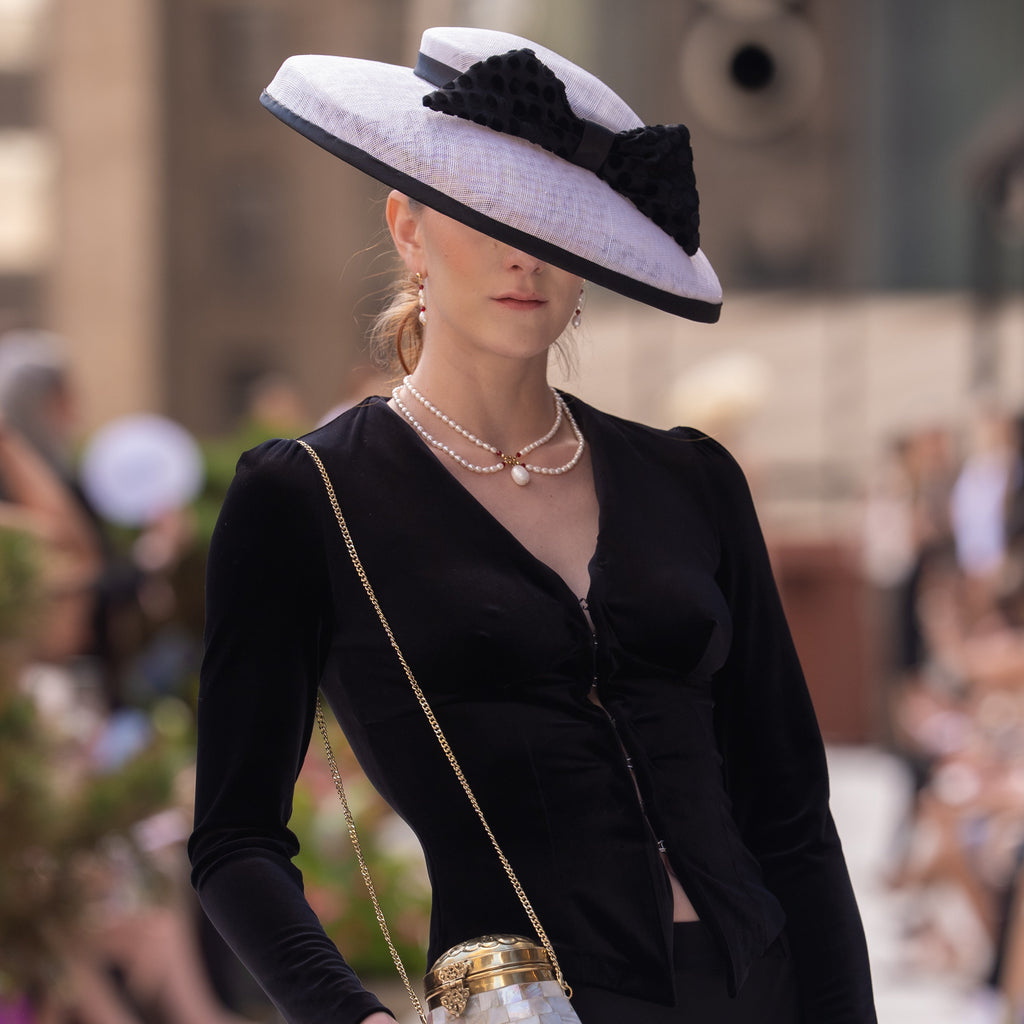 A romantic, vintage inspired necklace. It features real freshwater pearls, red crystals, and 18k real gold plated beads. It is being worn by a model during New York Fashion Week. 