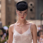 A vintage inspired necklace that features real freshwater pearl, imitation pearl, and a mother of pearl centre pendant. The metal is 18k real gold plated stainless steel. The necklace is worn by a model during New York Fashion Week. 