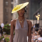 An 18k real gold plated charm necklace, worn by a model, during New York Fashion Week. The necklace features a mother of pearl locket and a string of real freshwater pearls. 