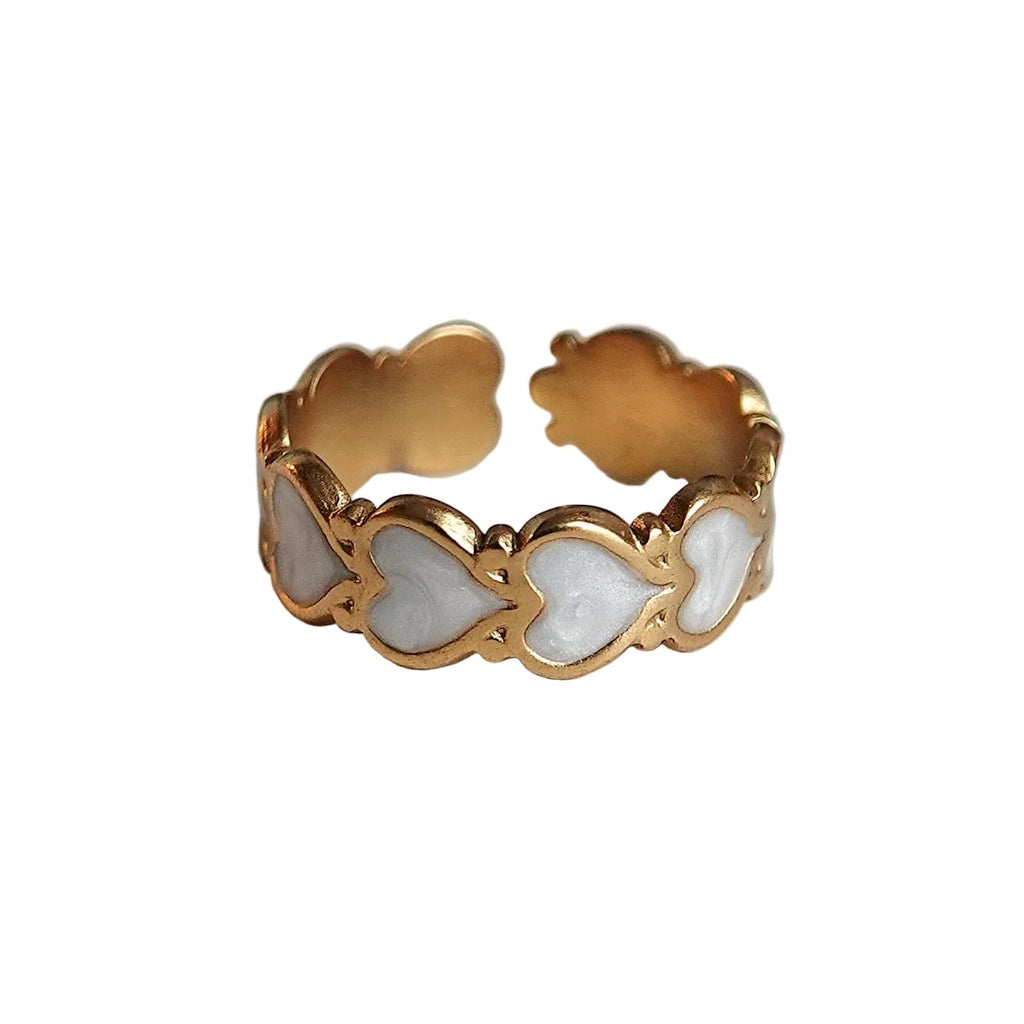 Gold ring with a white stone on a light gray background